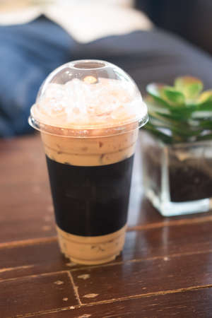 Glass of ice latte coffee on wooden table for drink