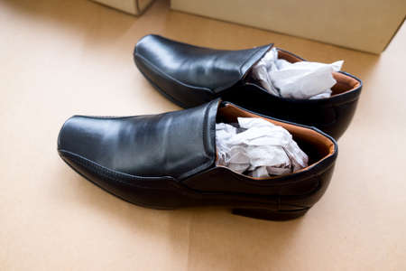 New leather black men shoes on brown paper backgroundの写真素材