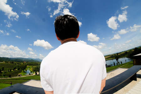 Young man with white shirt see beautiful sky vacation time and summer holiday conceptsの写真素材