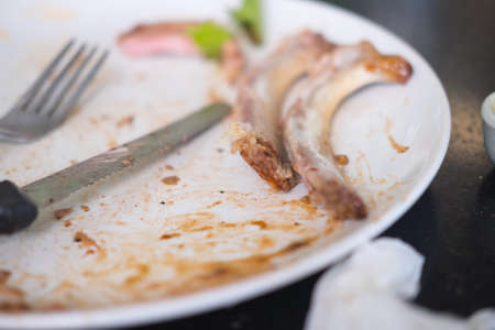 Bone after eating steak on white dishの写真素材