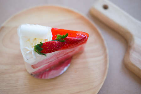 Homemade New York cheesecake on wooden plate decorated by fresh strawberryの写真素材