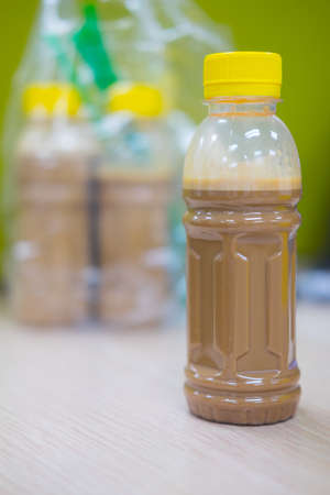 Ice mocha coffee in plastic bottle on wooden tableの写真素材