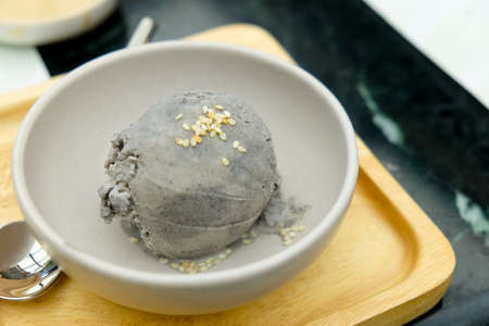 Trendy food. Gray ice cream with sesame in a white bowl