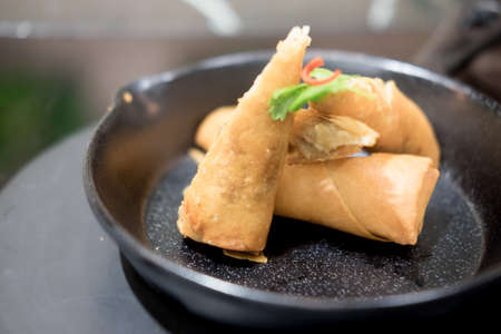Fried Chinese traditional spring rolls on black dish