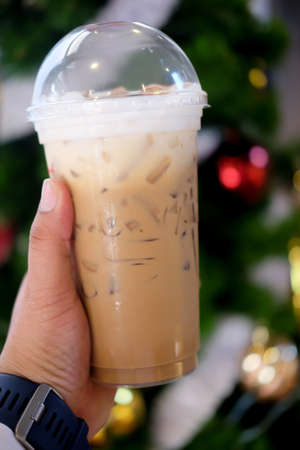 Iced coffee hold by hand ready to drinkの写真素材