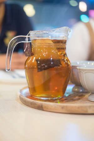 Hot tea in glass jar and ceramic tea cup. Healthy hot tea for breakfastの写真素材