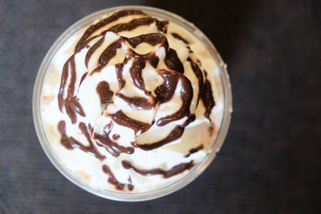 Drink covered with whipped cream and chocolate sauce, top viewの写真素材