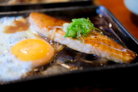 Salmon Teriyaki with fried egg on plateの写真素材