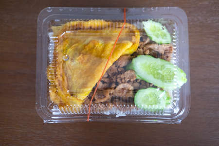 Fried pork with garlic pepper and fried egg in boxの写真素材