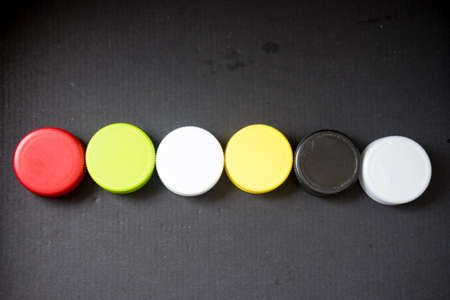 Five colored plastic bottle cap on black backgroundの写真素材