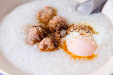 Rice porridge with ground pork and eggの写真素材