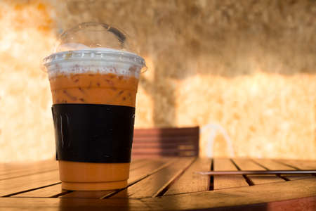 Iced Thai milk tea with milk on wood tableの写真素材