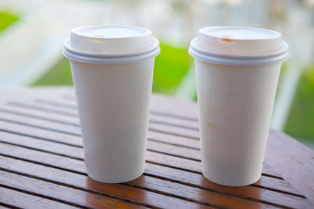 Two white paper cup for hot coffee or tea on wood tableの写真素材