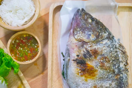 Close up tilapia grilled with vegetable on wood tray