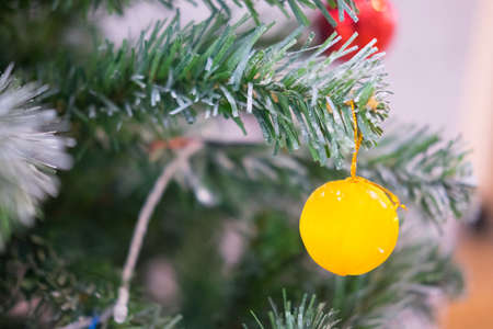 Yellow Christmas ball on Christmas tree branchの写真素材