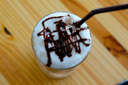 Top view Ice drink with  foam milk and chocolate sauce