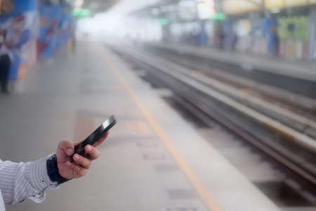 Businessman using smartphone with maps application in public transportation.の写真素材