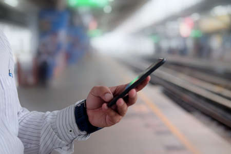 Businessman using smartphone with maps application in public transportation.の写真素材