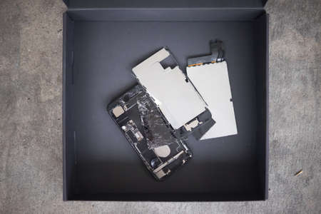 Broken phones in box preparing for recycling and disposalの写真素材
