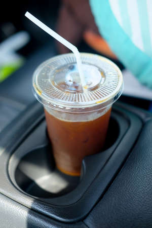 A single iced coffee cup inside the carの写真素材