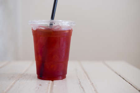 Glass of cold rose hip tea on wood table