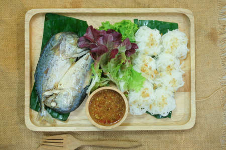 Wrapped fried mackerel served with fresh vegetable and special sauce on wood tray
