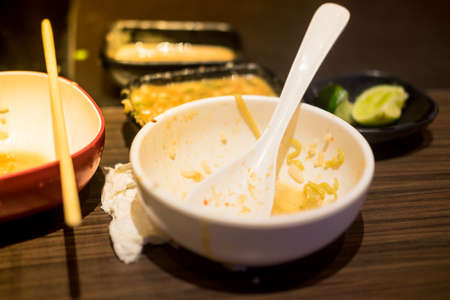 Empty dishes after eating on a wooden table at restaurantの写真素材