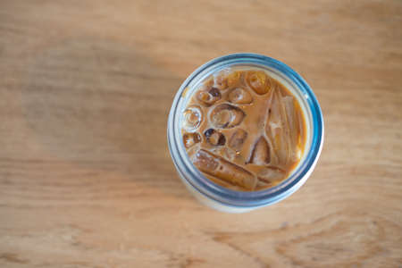 Glass of ice latte coffee on wooden table for drink on wooden table, top viewの写真素材