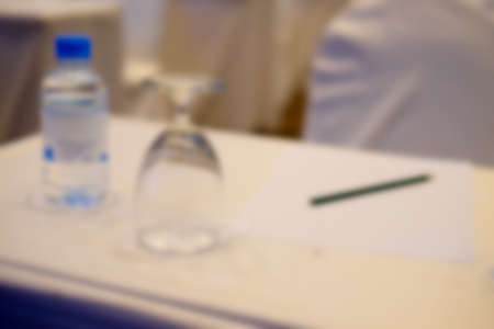 Blur background of pencil and glass for drink on the table in the seminar or conference hall room. Business meeting conceptの写真素材