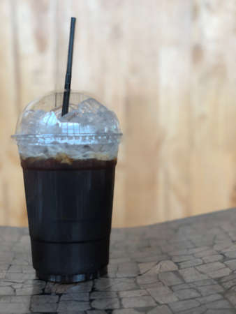 Iced black coffee or iced Americano with straw on wood tableの写真素材