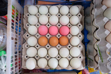 Brown eggs white eggs (Salted eggs) and pink eggs (Preserved eggs or Century eggs) in black tray.