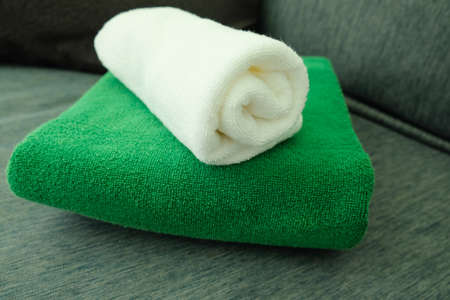 Stack of white and green clean towels in bathroom