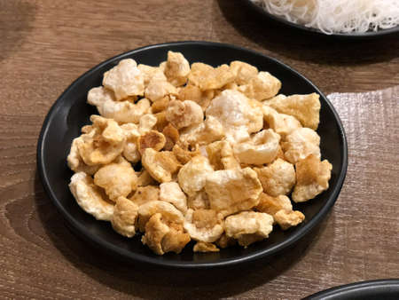 Crispy deep fried pork skin or pork rind in dish, popular Northern Thai food