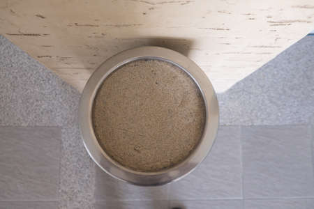 Stainless steel ashtray and sand and cigarette. Top viewの写真素材