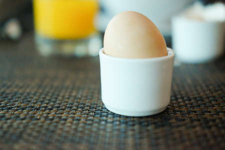 Soft-boiled egg in ceramic egg-cup. Breakfast concept. Selective focusの写真素材