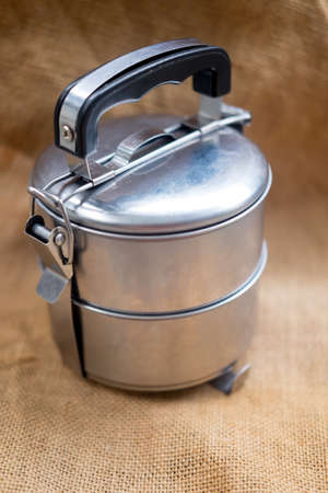 Stainless steel tiffin box on sacking cloth background