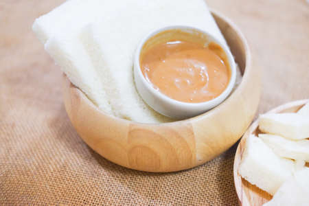 Orange pandan custard and steamed bread plate in wooden bowl