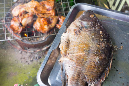 Grilled fish on tray ready to grill on stove at street food