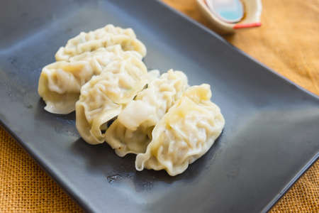 Gyoza with pork meat on black dishの写真素材