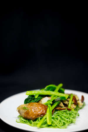 Roasted duck with green jade noodles on white dish