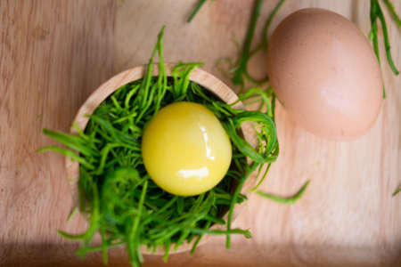 Thai local vegetable, Acacia pennata or Cha-om (Thai Language) with egg to make omelet on wooden trayの写真素材