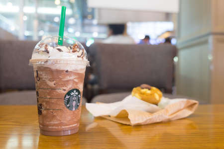 Samut Prakan, Thailand - MAY 6, 2018: Cup of Starbucks Chocolate Frappuccino with whipped cream and muffin on wood table in Starbucks coffee shop. (Selective focus shallow depth of field)のeditorial素材