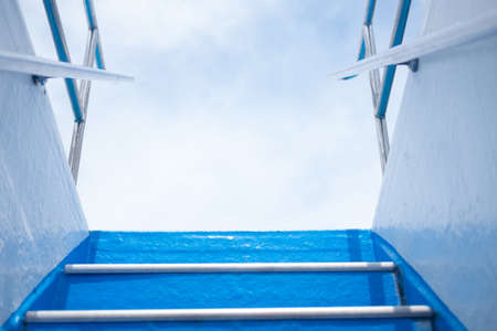 Ferry boat blue steps seen from below on a sunny dayの写真素材