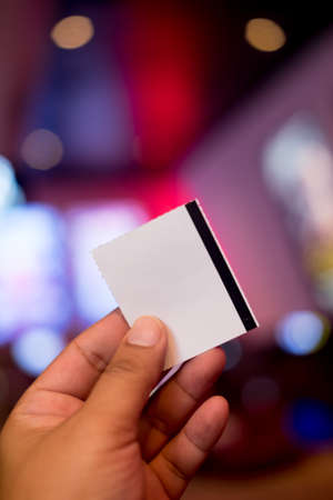 Hand holding white blank ticket paper, close upの写真素材