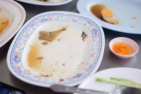 White empty dishes after eating, leftover food conceptの写真素材