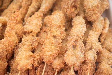 A street vendor sells fried chicken in skewersの写真素材