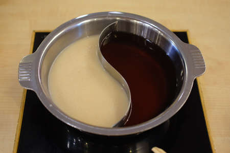 Double flavor hot pot cooking for Sukiの写真素材