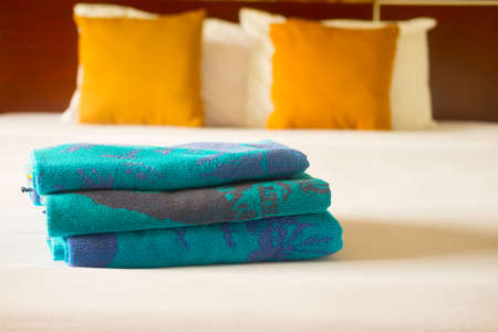 Stacked towel and new bed sheet in the hotel for customerの写真素材