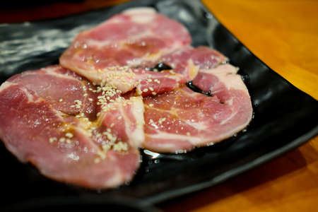 Raw beef with sauce and white sesame in black dish