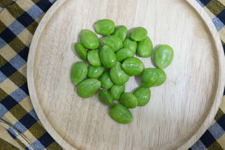 Parkia speciosa seeds or bitter bean on wooden trayの写真素材